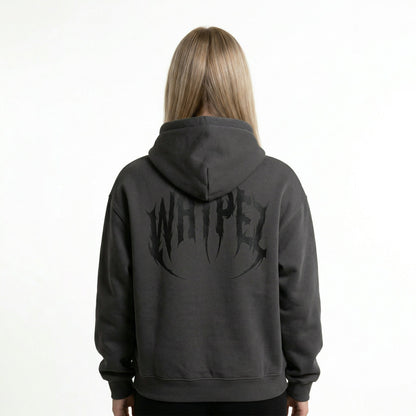 female-Rückansicht des Backfire Detonator Hoodies in Anthrazit getragen von einer Frau, mit großem schwarzem WHYPEZ Logo-Print im Metal-Stil.